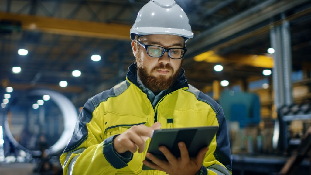 manufacturing worker using tablet in factory after digitization