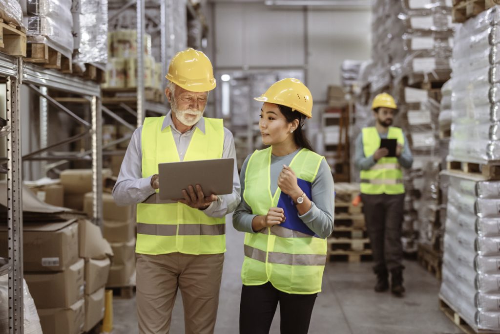two workers using laptop in warehouse after digital transformation