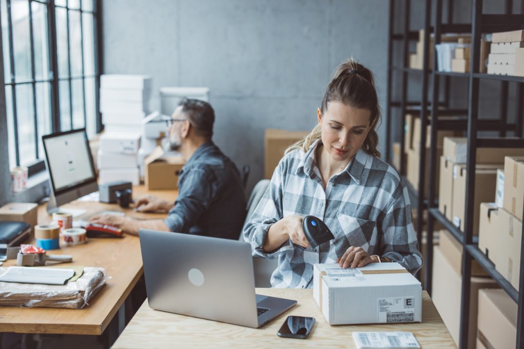 A small business owner scans in new inventory from her supply chain, emphasizing the importance of having world-class suppliers