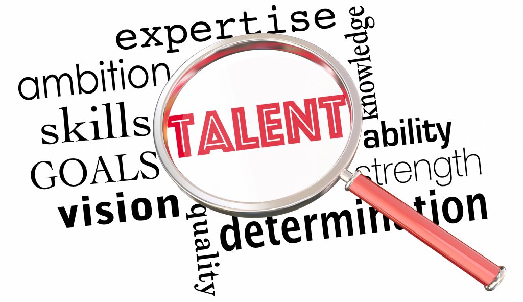 the word talent under a magnifying glass with other words ambition, skills, goals, vision, expertise, ability, determination